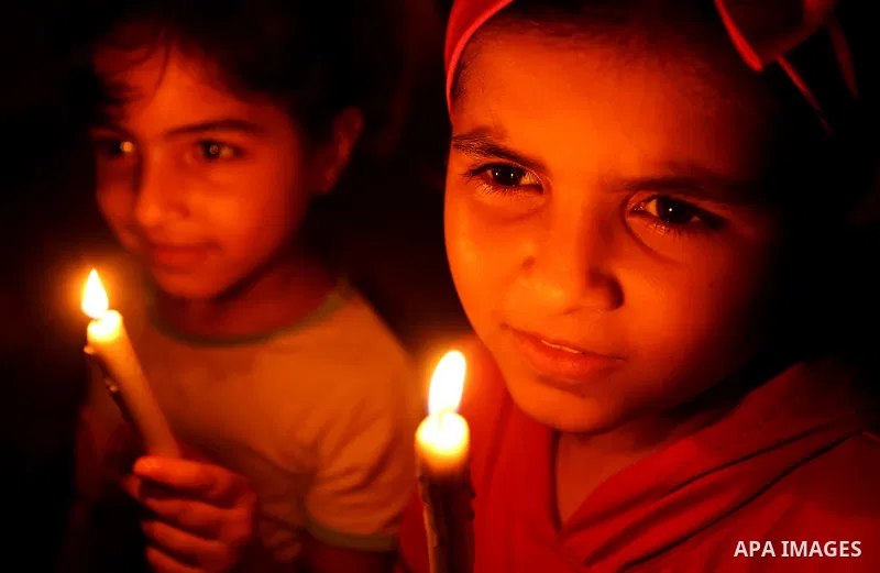 Palestinian girls hold candles during a protest against the blockade on Gaza, in Khan Younis in the southern Gaza Strip July 14, 2017. Photo by Ashraf Amra