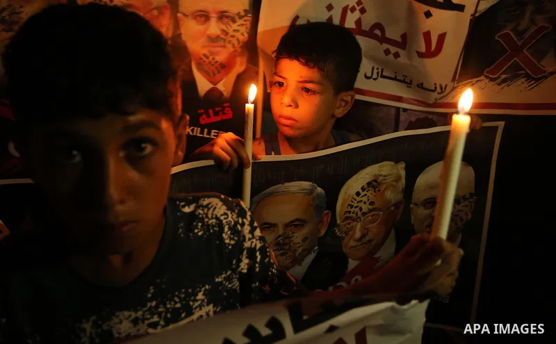Palestinian boys hold candles and posters during a protest against the blockade on Gaza, in Khan Younis in the southern Gaza Strip July 14, 2017. Photo by Ashraf Amra