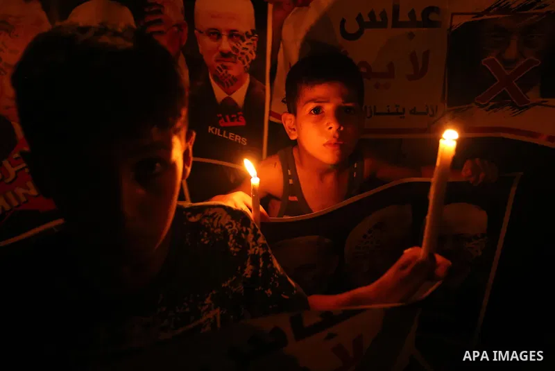 Palestinian boys hold candles and posters during a protest against the blockade on Gaza, in Khan Younis in the southern Gaza Strip July 14, 2017. Photo by Ashraf Amra