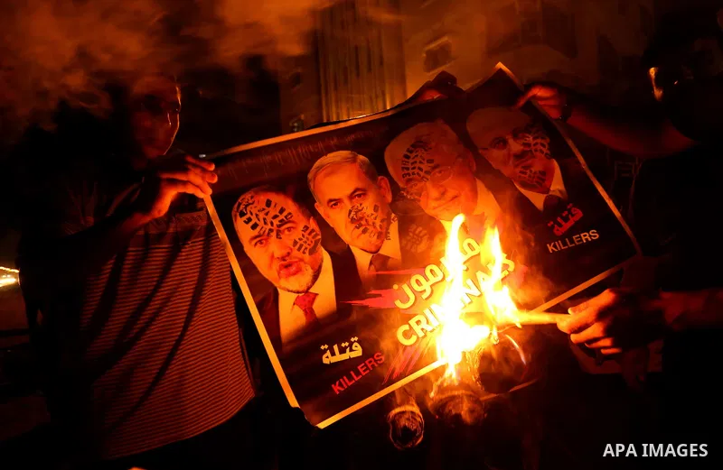 Palestinians burn a poster depicting Palestinian President Mahmoud Abbas, Israeli Prime Minister Benjamin Netanyahu and Israeli Defence Minister Avigdor Lieberman as they step on it during a protest against the blockade...