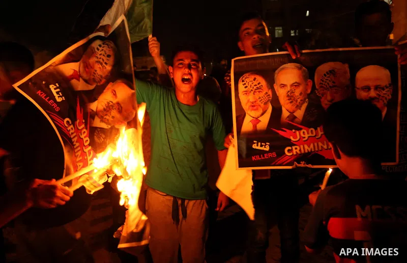 Palestinians burn a poster depicting Palestinian President Mahmoud Abbas, Israeli Prime Minister Benjamin Netanyahu and Israeli Defence Minister Avigdor Lieberman as they step on it during a protest against the blockade...
