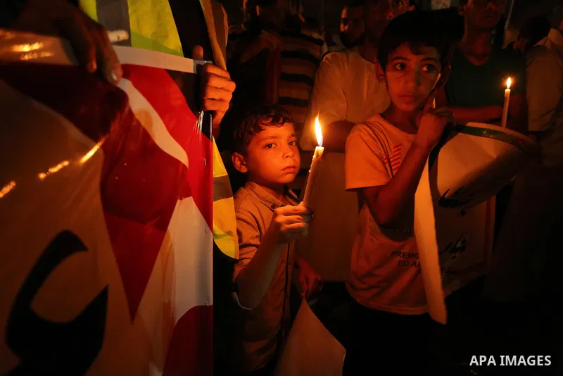 Palestinian boys hold candles during a protest against the blockade on Gaza, in Khan Younis in the southern Gaza Strip July 14, 2017. Photo by Ashraf Amra