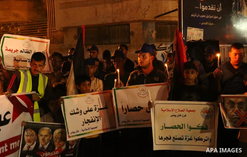 Palestinians hold placards during a protest against the blockade on Gaza, in Khan Younis in the southern Gaza Strip July 14, 2017. Photo by Ashraf Amra