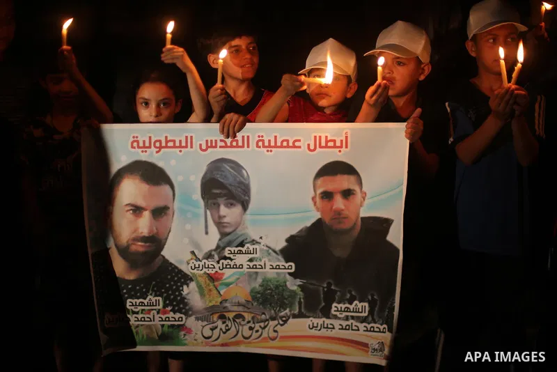 Palestinian children hold candles and posters during a protest against the blockade on Gaza, in Gaza city July 14, 2017. Photo by Mohammed Asad