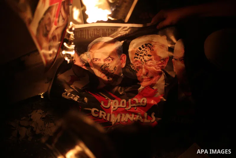 Palestinians burn a poster depicting Palestinian President Mahmoud Abbas, Israeli Prime Minister Benjamin Netanyahu and Israeli Defence Minister Avigdor Lieberman as they step on it during a protest against the blockade...