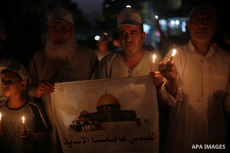 Palestinias hold candles and posters during a protest against the blockade on Gaza, in Gaza city July 14, 2017. Photo by Mohammed Asad