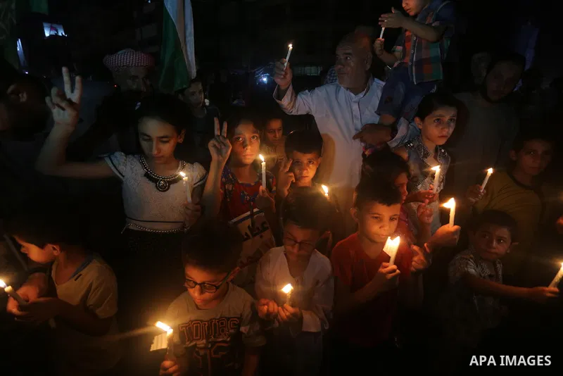 Palestinian children hold candles during a protest against the blockade on Gaza, in Gaza city July 14, 2017. Photo by Mohammed Asad