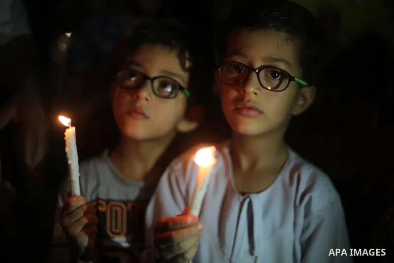 Palestinian children hold candles during a protest against the blockade on Gaza, in Gaza city July 14, 2017. Photo by Mohammed Asad