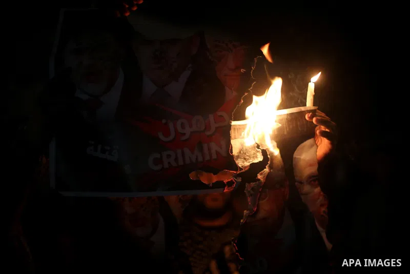 Palestinians burn a poster depicting Palestinian President Mahmoud Abbas, Israeli Prime Minister Benjamin Netanyahu and Israeli Defence Minister Avigdor Lieberman as they step on it during a protest against the blockade...