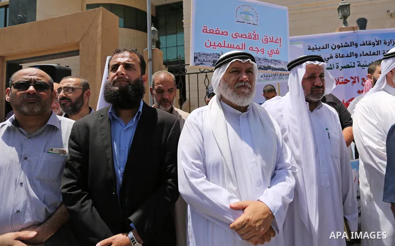 Members of the Palestine Scholars Association take part in a protest against the recent closure of the Al-Aqsa Mosque compound by Israel, in Gaza City on July 16, 2017. Photo by Ashraf Amra