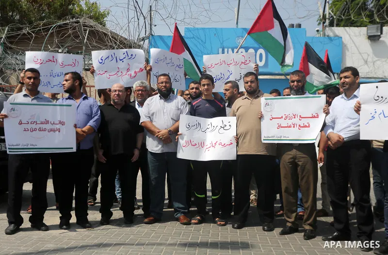 Palestinian released prisoners from Israeli jails hold placards during a protest demanding their salaries in front of the headquarter United Nation "UNSCO" in Gaza city on July 17, 2017. Photo by Mohammed Asad