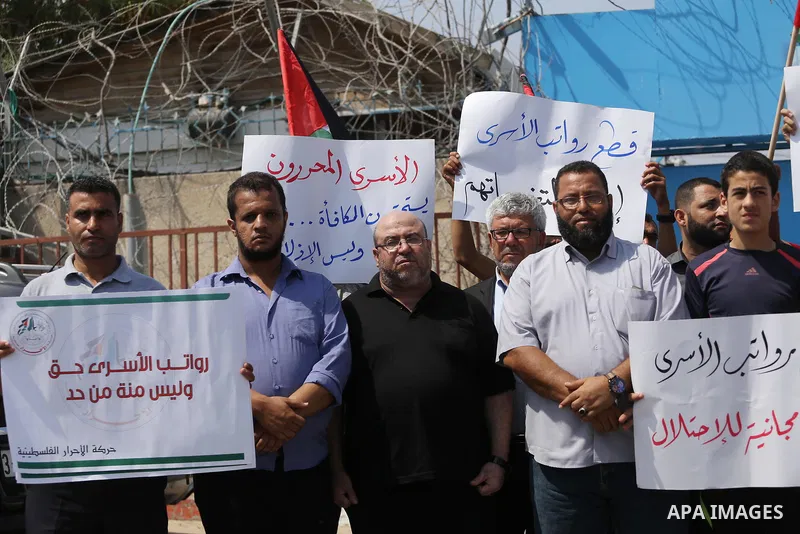 Palestinian released prisoners from Israeli jails hold placards during a protest demanding their salaries in front of the headquarter United Nation "UNSCO" in Gaza city on July 17, 2017. Photo by Mohammed Asad