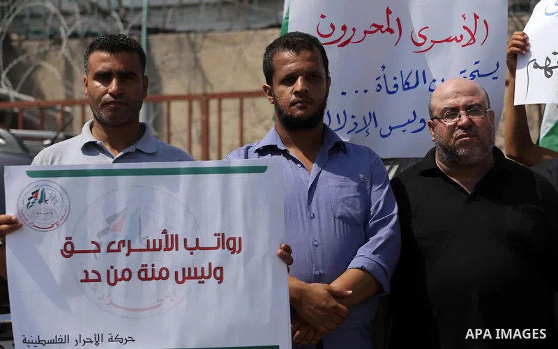 Palestinian released prisoners from Israeli jails hold placards during a protest demanding their salaries in front of the headquarter United Nation "UNSCO" in Gaza city on July 17, 2017. Photo by Mohammed Asad