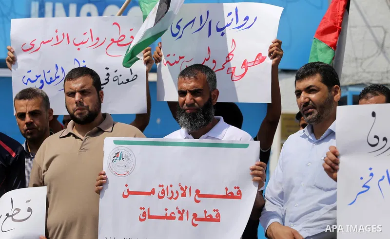 Palestinian released prisoners from Israeli jails hold placards during a protest demanding their salaries in front of the headquarter United Nation "UNSCO" in Gaza city on July 17, 2017. Photo by Mohammed Asad