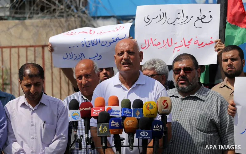 Palestinian released prisoners from Israeli jails hold placards during a protest demanding their salaries in front of the headquarter United Nation "UNSCO" in Gaza city on July 17, 2017. Photo by Mohammed Asad