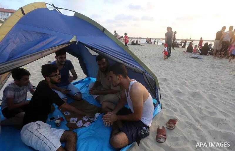 Palestinians enjoy their time at the beach of the Mediterranean sea on the coast of Gaza city on July 19, 2017. Photo by Yasser Qudih