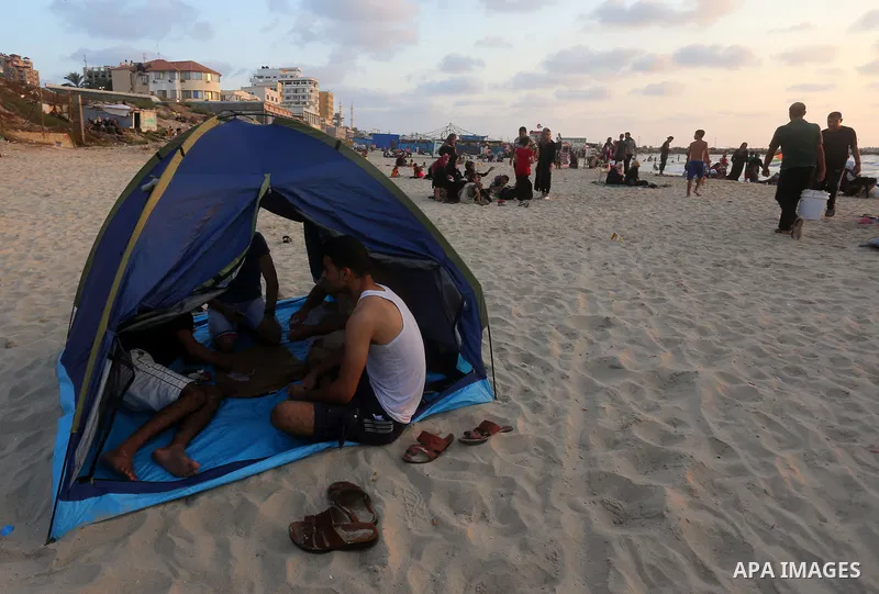 Palestinians enjoy their time at the beach of the Mediterranean sea on the coast of Gaza city on July 19, 2017. Photo by Yasser Qudih