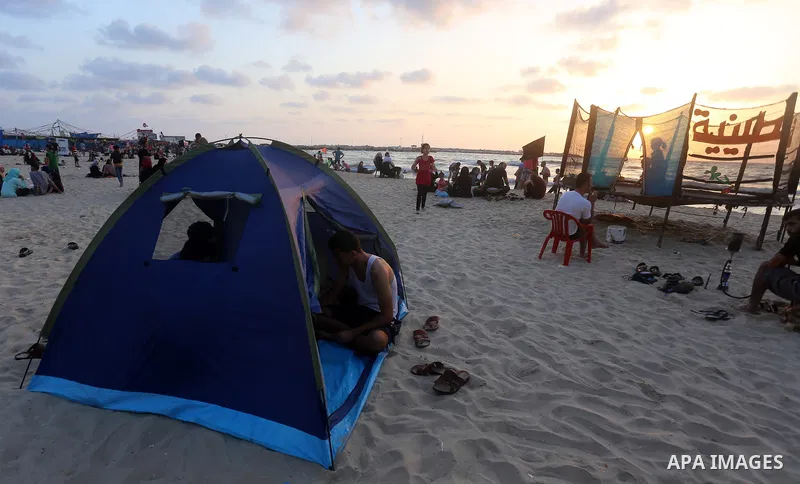 Palestinians enjoy their time at the beach of the Mediterranean sea on the coast of Gaza city on July 19, 2017. Photo by Yasser Qudih
