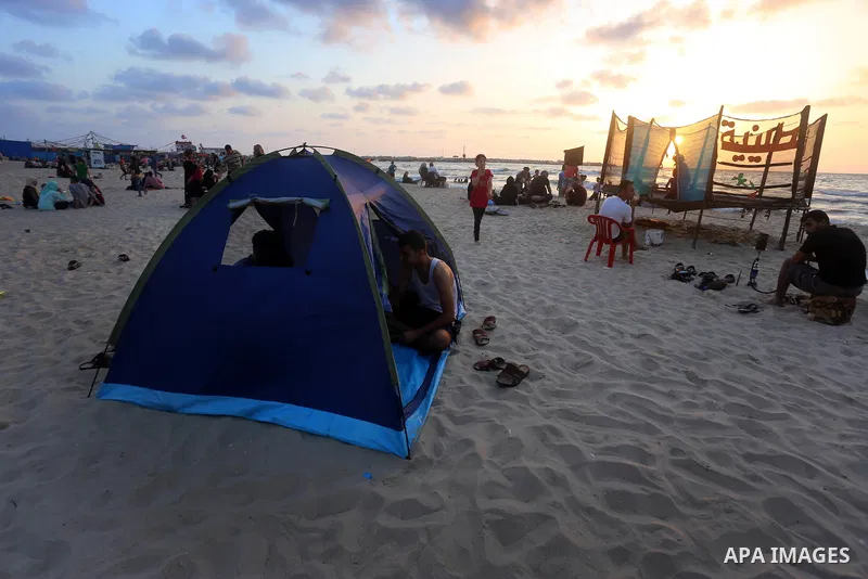 Palestinians enjoy their time at the beach of the Mediterranean sea on the coast of Gaza city on July 19, 2017. Photo by Yasser Qudih