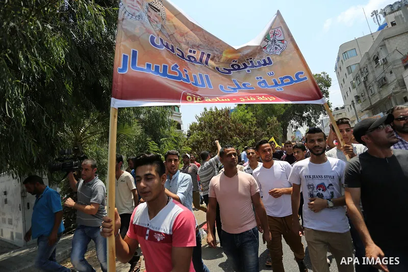 Palestinians Supporters of Fateh movement hold banners and march during a demonstration in Gaza City on July 20, 2017 against new Israeli security measures at Al-Aqsa mosque compound, which include metal detectors and ca...