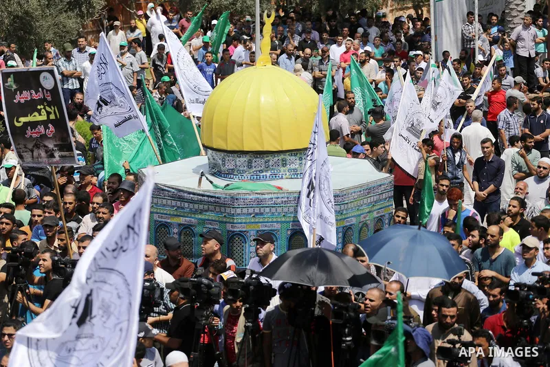 Palestinian demonstrators carry a model of the Dome of the Rock mosque during a protest against Israel's new security measures at the entrance to the al-Aqsa mosque compound, which include metal detectors and cameras, in...