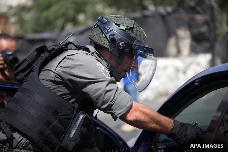 A member of Israeli security forces aims his weapon towards a Palestinian driver during clashes following Friday prayer outside Jerusalem's Old City on July 21, 2017, after Israeli police barred men under 50 from enterin...