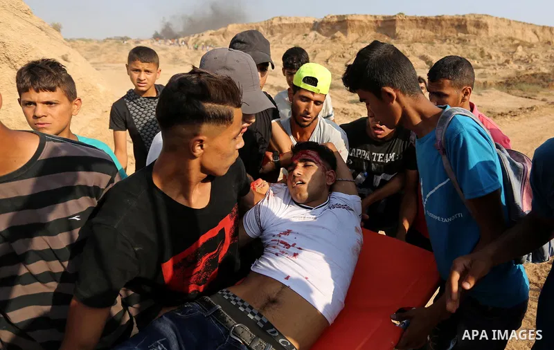 A wounded Palestinian protester is evacuated during clashes with Israeli security forces near the border between Israel and central Gaza Strip in a protest against Israel's new security measures at the entrance to the al...