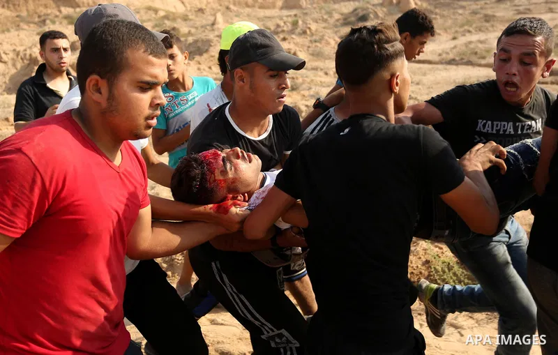 A wounded Palestinian protester is evacuated during clashes with Israeli security forces near the border between Israel and central Gaza Strip in a protest against Israel's new security measures at the entrance to the al...