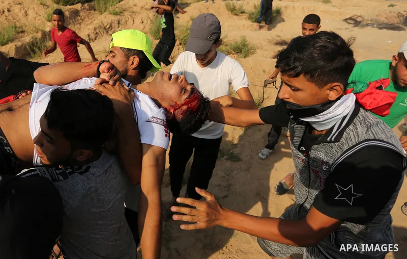 A wounded Palestinian protester is evacuated during clashes with Israeli security forces near the border between Israel and central Gaza Strip in a protest against Israel's new security measures at the entrance to the al...
