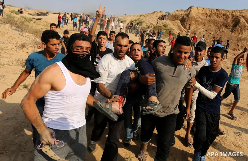 A wounded Palestinian protester is evacuated during clashes with Israeli security forces near the border between Israel and central Gaza Strip in a protest against Israel's new security measures at the entrance to the al...