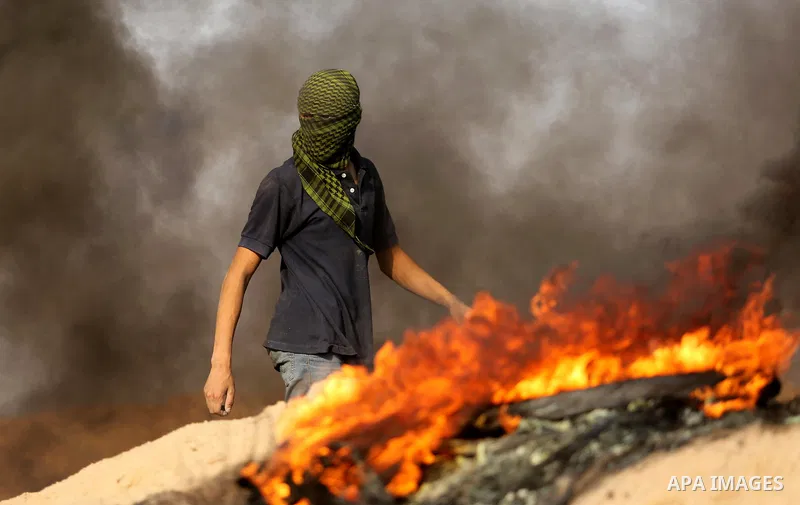 A Palestinian protester takes part during clashes with Israeli security forces near the border between Israel and central Gaza Strip in a protest against Israel's new security measures at the entrance to the al-Aqsa mosq...