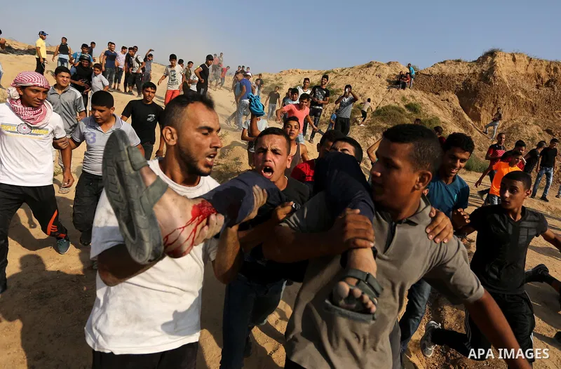 A wounded Palestinian protester is evacuated during clashes with Israeli security forces near the border between Israel and central Gaza Strip in a protest against Israel's new security measures at the entrance to the al...