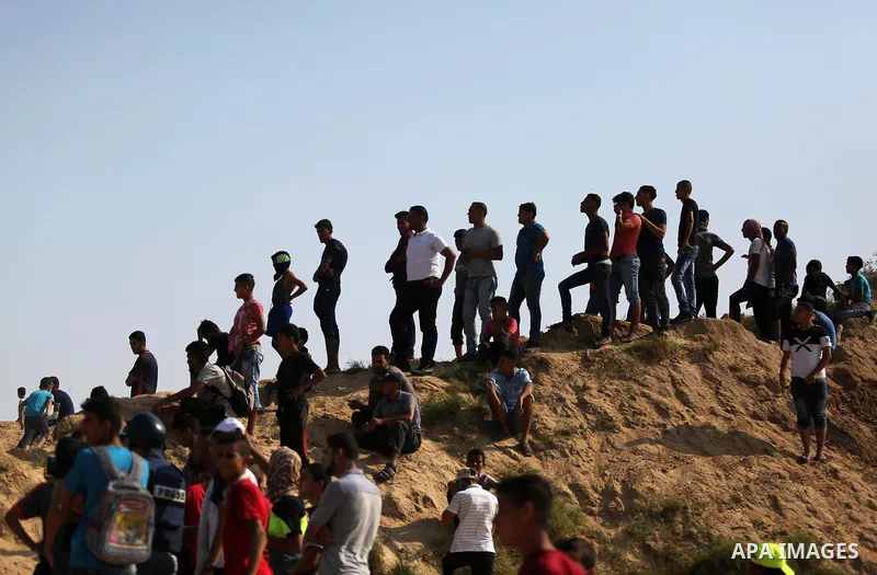 Palestinian protesters stand on top of a sandy hill during clashes with Israeli security forces near the border between Israel and central Gaza Strip in a protest against Israel's new security measures at the entrance to...
