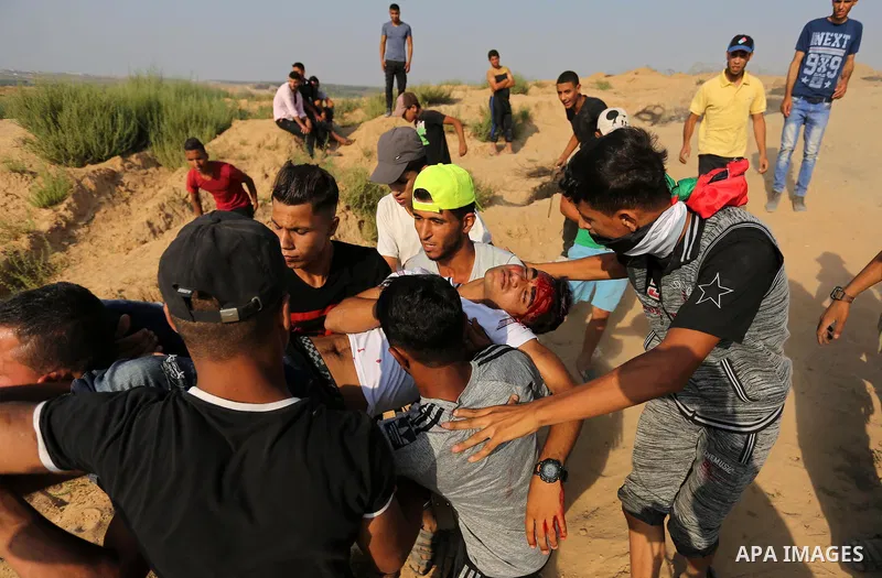 A wounded Palestinian protester is evacuated during clashes with Israeli security forces near the border between Israel and central Gaza Strip in a protest against Israel's new security measures at the entrance to the al...