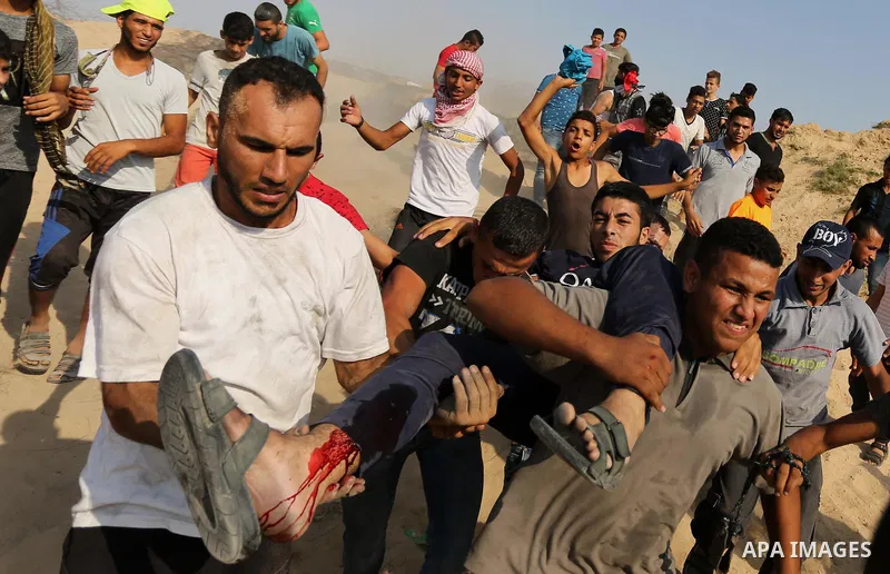 A wounded Palestinian protester is evacuated during clashes with Israeli security forces near the border between Israel and central Gaza Strip in a protest against Israel's new security measures at the entrance to the al...