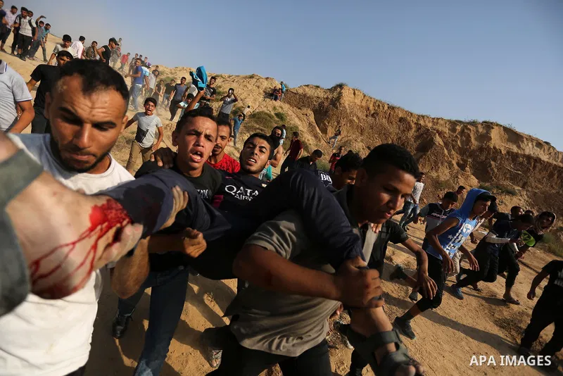 A wounded Palestinian protester is evacuated during clashes with Israeli security forces near the border between Israel and central Gaza Strip in a protest against Israel's new security measures at the entrance to the al...