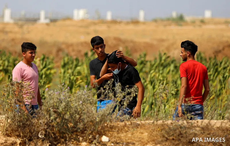 Palestinian protesters take cover during clashes with Israeli security forces near the border fence east of Jabalia refugee camp in a protest against Israel's new security measures at the entrance to the al-Aqsa mosque c...
