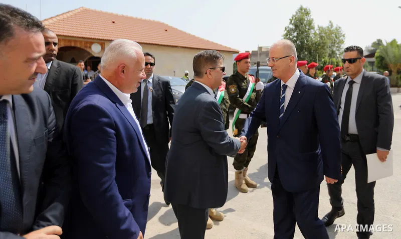 Palestinian Prime Minister Rami Hamdallah shakes hands with Palestinian Health Minister Jawad Awad during his visit to Salfit governorate in the West Bank on July 22, 2017. Photo by Prime Minister Office