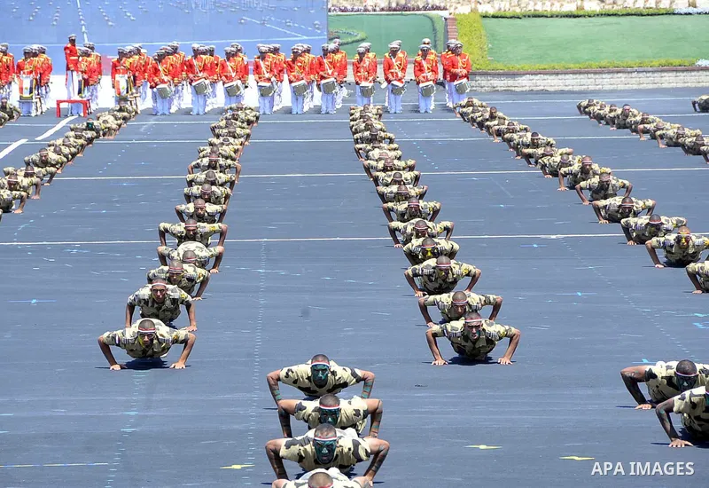 Military students stand at attention to mark the opening of the Mohamed Najib military base, the graduation of new graduates from military colleges, and the celebration of the 65th anniversary of the July 23 revolution a...