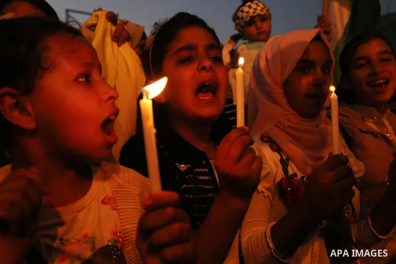 Palestinian children hold candles during a protest against Israel's newly-installed security measures at the entrance to the al-Aqsa mosque compound, in Khan Younis in the southern Gaza Strip July 23, 2017. Photo by Ashr...