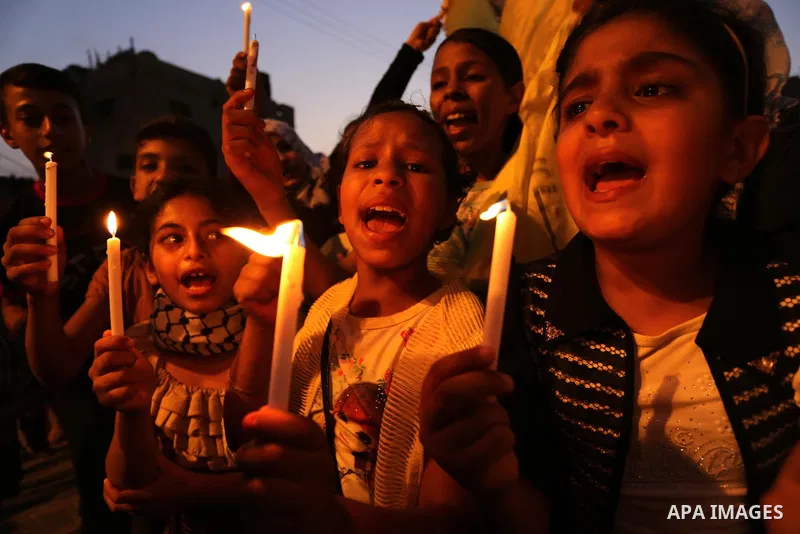 Palestinian children hold candles during a protest against Israel's newly-installed security measures at the entrance to the al-Aqsa mosque compound, in Khan Younis in the southern Gaza Strip July 23, 2017. Photo by Ashr...