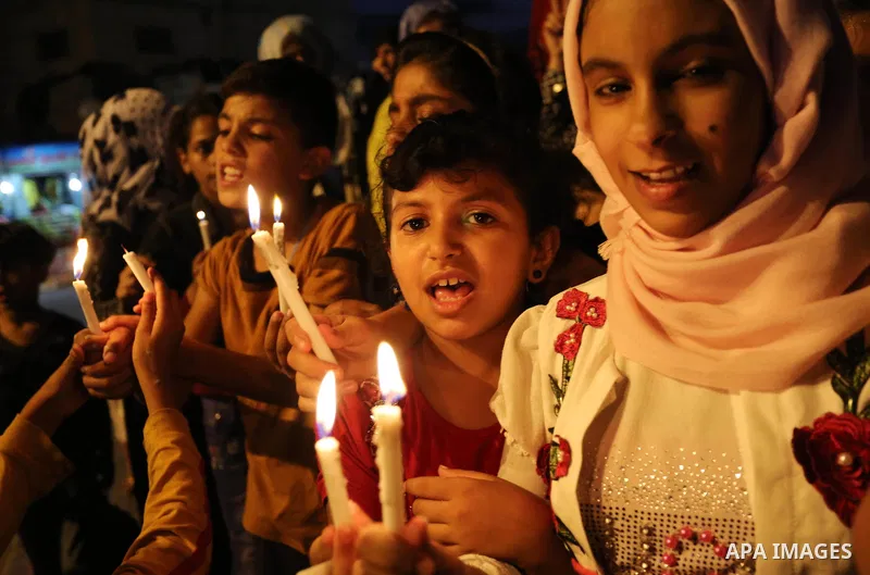 Palestinian children hold candles during a protest against Israel's newly-installed security measures at the entrance to the al-Aqsa mosque compound, in Khan Younis in the southern Gaza Strip July 23, 2017. Photo by Ashr...