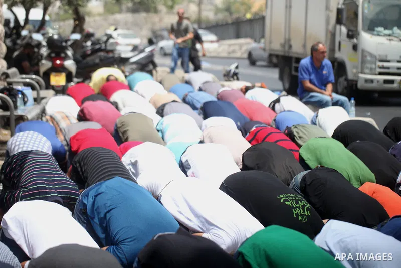 Palestinians pray outside the Lion's Gate main entrance to the Al-Aqsa mosque compound in Jerusalem's Old City on July 24, 2017 as Palestinians protest against Israel's newly-installed security measures at the entrance t...
