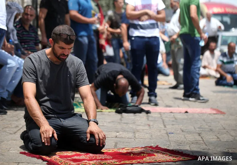 Palestinians pray outside the Lion's Gate main entrance to the Al-Aqsa mosque compound in Jerusalem's Old City on July 24, 2017 as Palestinians protest against Israel's newly-installed security measures at the entrance t...