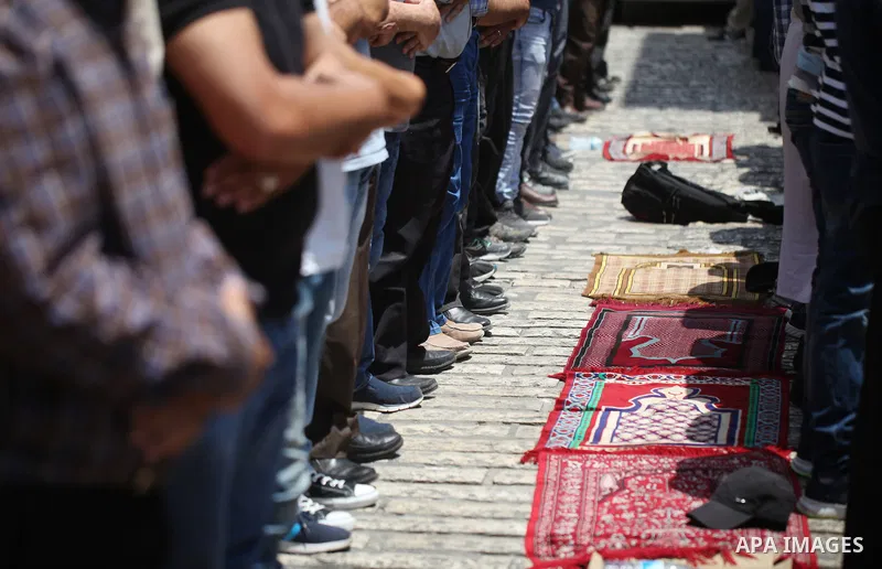 Palestinian Muslim worshippers pray outside Lions' Gate, a main entrance to the Al-Aqsa mosque compound in Jerusalem's Old City, on July 25, 2017. Dozens of Muslims have prayed in the street outside a major Jerusalem shr...
