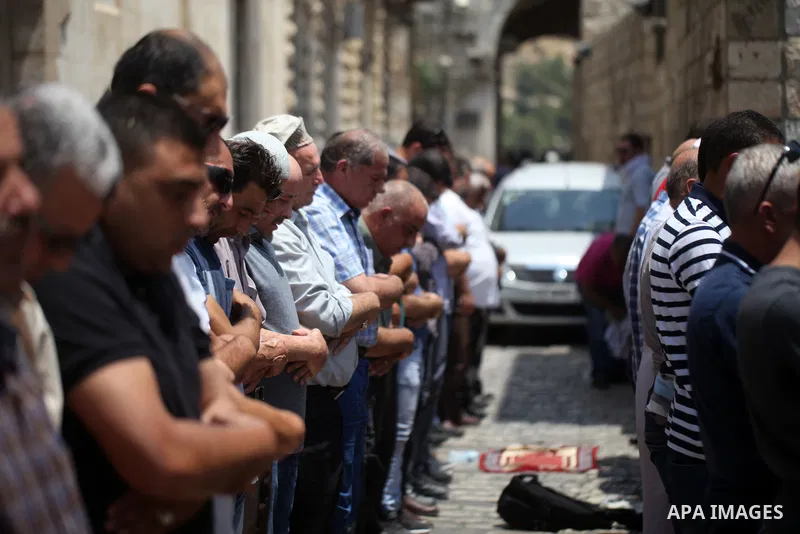 Palestinian Muslim worshippers pray outside Lions' Gate, a main entrance to the Al-Aqsa mosque compound in Jerusalem's Old City, on July 25, 2017. Dozens of Muslims have prayed in the street outside a major Jerusalem shr...