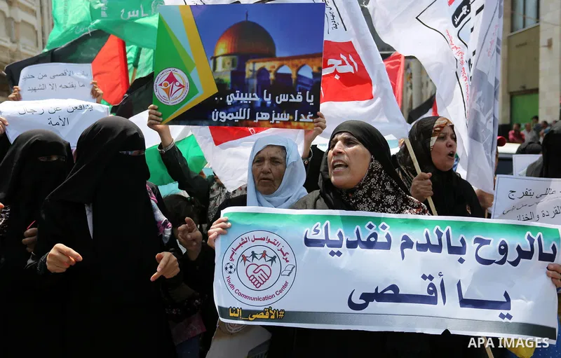 Palestinian protesters shout slogans and hold placards during a demonstration against Israeli security measures that were implemented at the Al-Aqsa mosque compound in Jerusalem the previous week prior to being removed a...