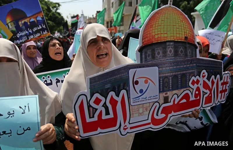 Palestinian protesters shout slogans and hold placards during a demonstration against Israeli security measures that were implemented at the Al-Aqsa mosque compound in Jerusalem the previous week prior to being removed a...