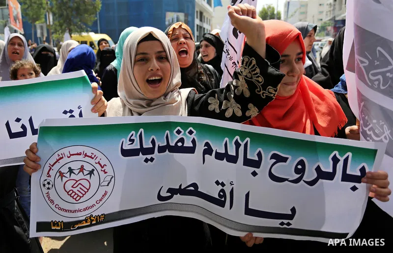 Palestinian protesters shout slogans and hold placards during a demonstration against Israeli security measures that were implemented at the Al-Aqsa mosque compound in Jerusalem the previous week prior to being removed a...