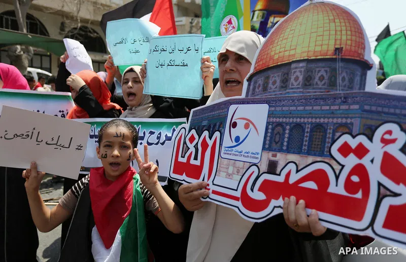 Palestinian protesters shout slogans and hold placards during a demonstration against Israeli security measures that were implemented at the Al-Aqsa mosque compound in Jerusalem the previous week prior to being removed a...